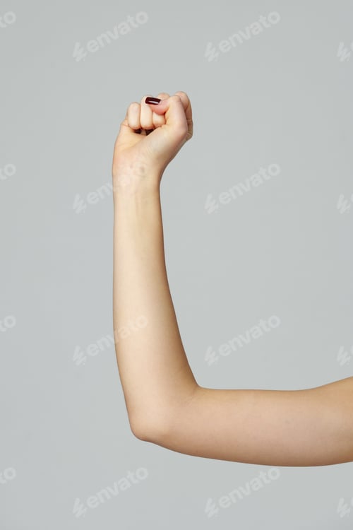 Preview: Female hand with clenched fist on gray background