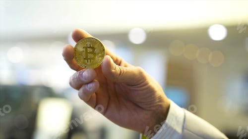 Preview: Businessman hand holding glowing bitcoin sign. Stock. Virtual money concept and Financial growth