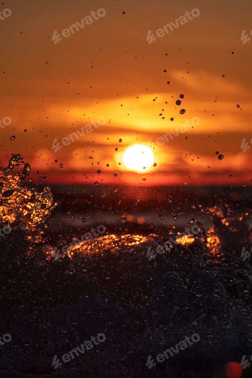 Vorschau: Perfekter Sonnenaufgang am Strand, wobei die Sonne am Horizont einen atemberaubenden Orangeton erzeugt