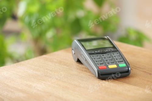 Preview: Modern payment terminal on table indoors. Space for text