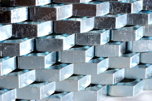 Preview: Close-up wall of numerous chrome metal nuts