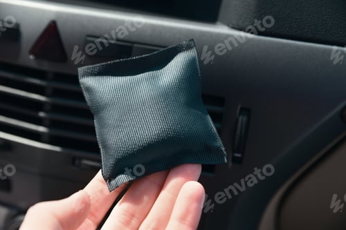 Preview: Woman with car air freshener in automobile, closeup
