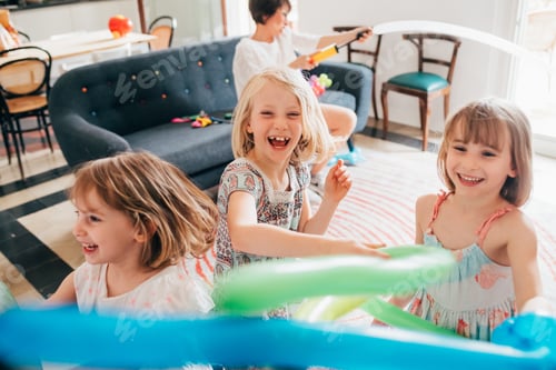 Preview: Smiling Children Playing with Balloons at Home