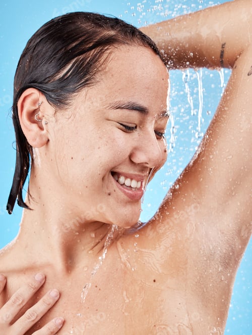 Preview: Skincare, cleaning and woman in shower in studio isolated on a blue background. Water splash, hygie