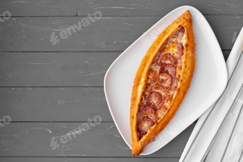 Preview: Turkish stuffed flatbread pide on gray wooden table