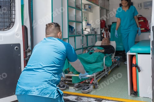 Preview: Health workers taking a patient out of an ambulance
