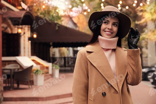 Preview: Young woman wearing stylish clothes on city street, space for text. Autumn look