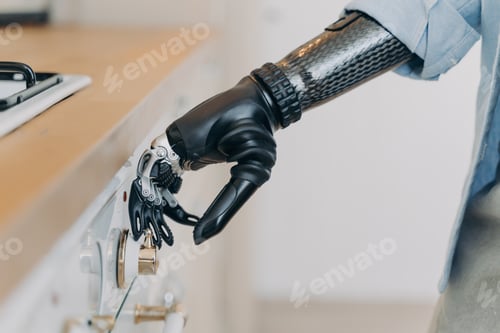 Preview: Electronic cyber hand of disabled person is switching a stove. Sensor in fingers and wrist joint.