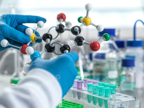 Preview: Scientist holding a molecular model in a laboratory setting.
