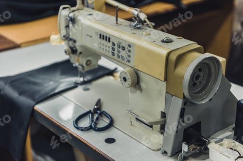 Preview: selective focus of tailor workplace with sewing machine at workshop