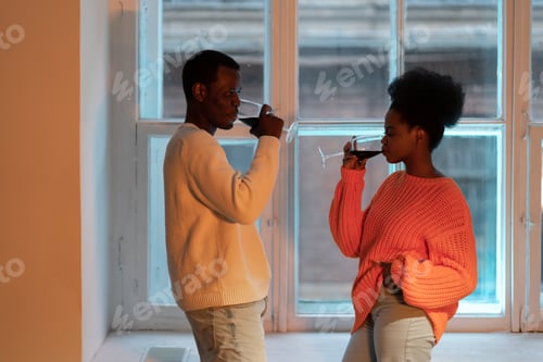 Preview: Young african couple enjoy romantic evening with wine at home, black man and woman at date night