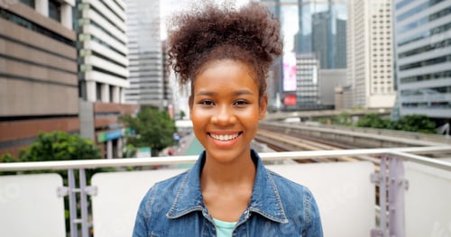 Preview: Portrait of smiling happy woman walking in street with backpack