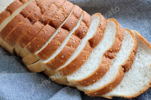Preview: Loaf of fresh sliced bread with sesame seed crust