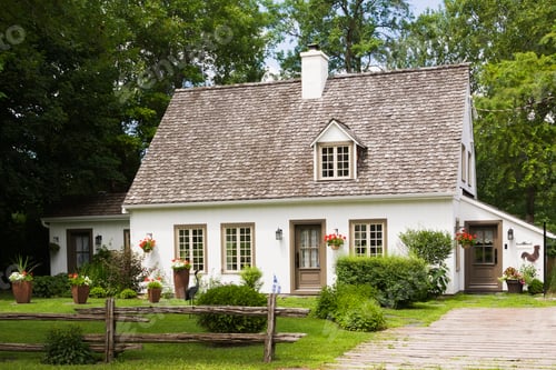 Preview: Old (circa 1886) white with beige and brown trim Canadiana cottage style home facade in summer,