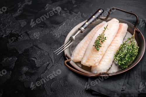 Preview: Raw Loin cod fish fillets ready for cooking whitefish in stell tray. black background. top view