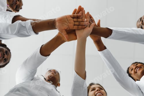 Preview: Group of doctors putting hands together in clinic. Unity concept.