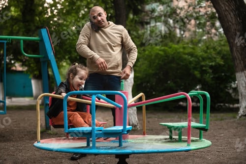 Preview: family having fun on the playground on a swing