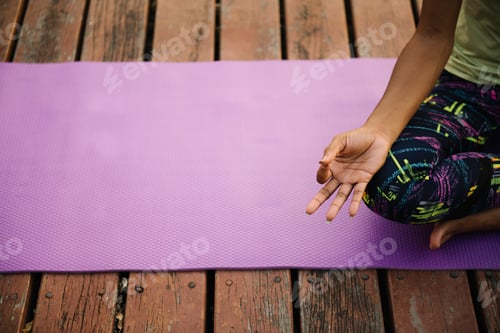 Preview: Black lady making a Swastikasana pose in a park