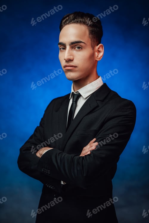 Preview: Handsome young man in elegant suit keeping arms crossed and looking on the camera