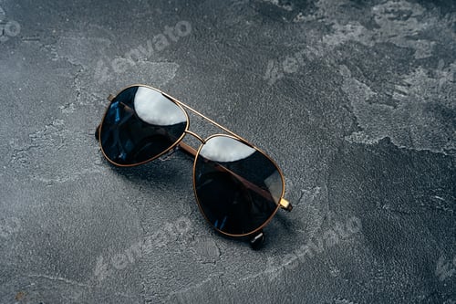 Preview: New dark aviator glasses on grey concrete background