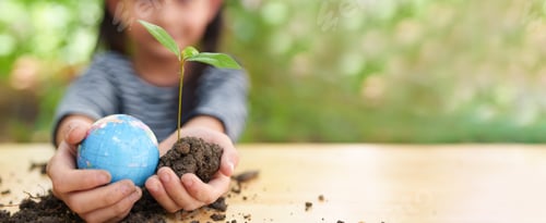 Preview: Banner of blurred little girl is holding plant and globe model together.