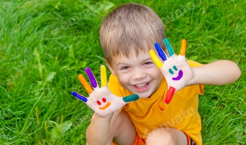 Preview: Children's hands in the colors of summer, a smile on the boy's palm.