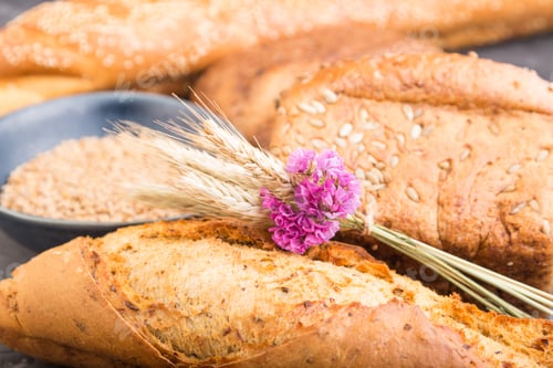 Preview: Different kinds of fresh baked bread on a black concrete background. side view, selective focus.