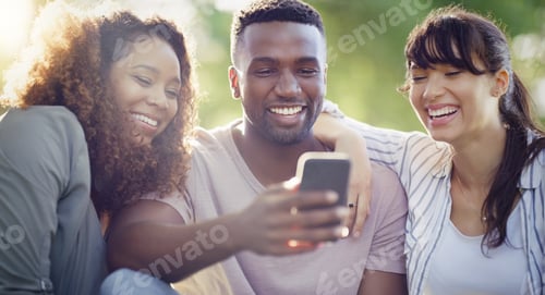 Preview: Shot of a cheerful group of friends using a cellphone together while relaxing outdoors