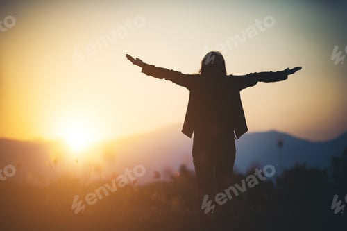 Preview: Silhouette of woman praying over beautiful sky background
