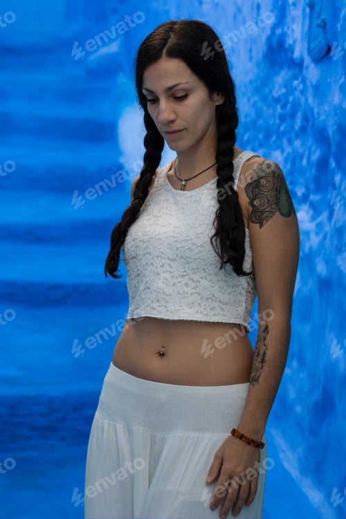Preview: Young woman looking on blue wall