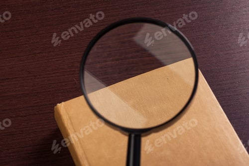 Preview: Magnifying glass and book o the wooden background