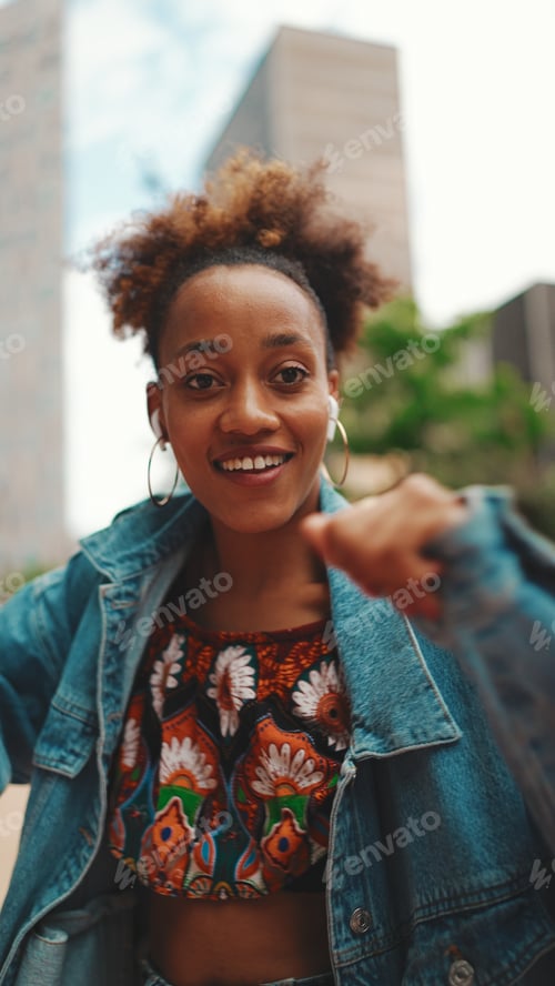 Preview: Closeup, smiling African listening to music on headphones and dancing outdoors.