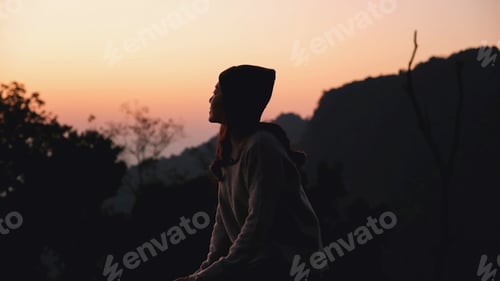 Preview: A woman looking at mountain views at dawn