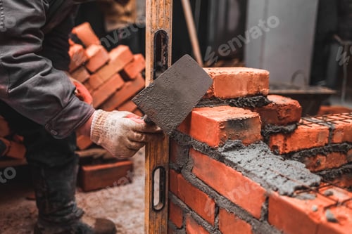 Preview: Bricklayer puts bricks to make a wall
