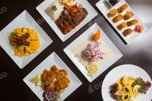 Preview: Typical Peruvian food seen from above on dark wooden table.