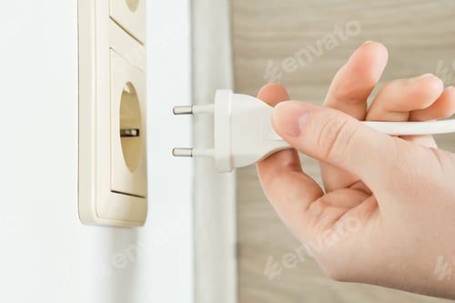 Preview: Hand holding electrical plug ready for power connection