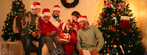 Preview: Happy multi-generation family gathered at home on Christmas day, exchanging Christmas presents