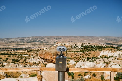 Preview: Binoculars on mountains background with sky on horizon