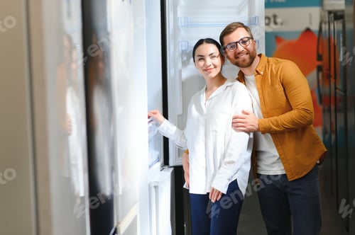 Preview: couple, satisfied customers choosing fridge in appliances store