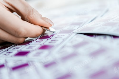 Preview: selective focus of woman holding coin and scratching lottery ticket