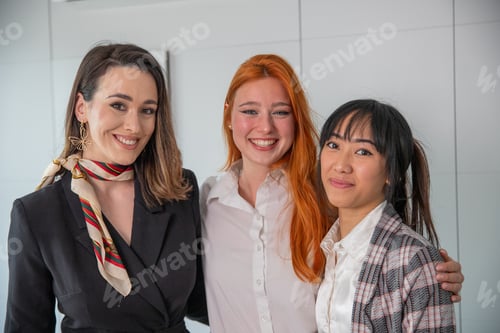 Preview: Three young business women smiling together in the office, multi ethnic group