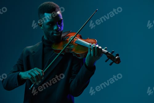 Preview: Elegant musician playing the violin in a black suit on a vibrant blue background