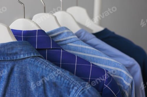 Preview: Collection of Blue Shirts Hanging on White Hangers