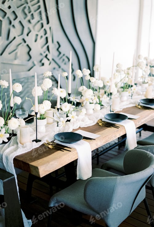 Preview: Black plates stand on napkins on a festive table near bouquets of flowers