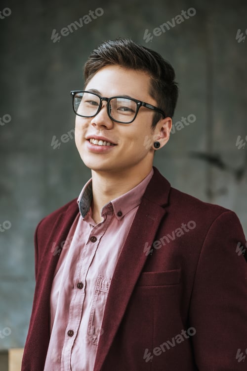 Preview: portrait of handsome young kazakh man in eyeglasses smiling at camera
