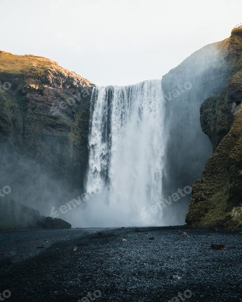 Preview: Breathtaking view of a powerful waterfall surrounded by rocky cliffs in Iceland