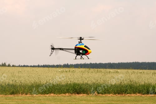 Preview: Selective focus shot of a helicopter over a big farmland