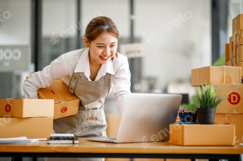 Preview: Startup small business entrepreneur or freelance Asian woman using a laptop with box, Young success