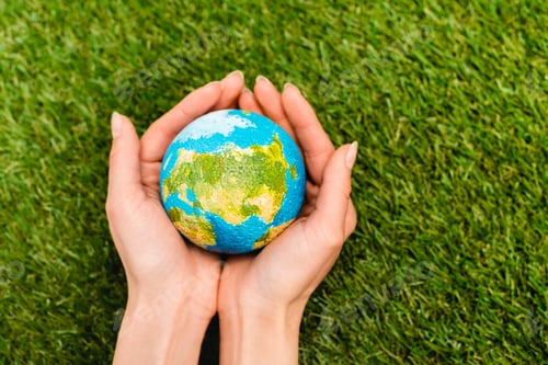 Preview: Cropped view of globe in female hands on green background, earth day concept