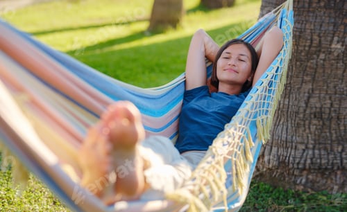 Preview: young beautiful lady posing while lying on hammock,